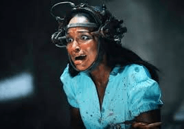 Still from the movie Saw: a terrified woman wearing the "reverse bear trap" on her head